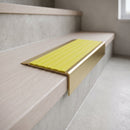 BN71SLR solid brass stair nosing in Satin Brass finish with Yellow Castellated insert, fitted to a step edge