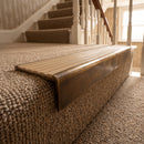 Solid brass stair nosing, 59.5mm tread with a 30mm raked-back front, in Antique Brass finish, fitted to a staircase