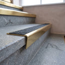 Solid brass stair nosing, 59.5mm tread with a 30mm raked-back front, in Polished Brass finish, fitted to a staircase