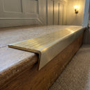 Solid brass stair nosing, 59.5mm tread with a 30mm raked-back front, in Satin Brass finish, fitted to a staircase