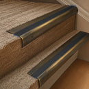 Solid brass 63.5mm bullnose stair nosing fitted to a step - Antique Brass with Black Olympic Grip insert