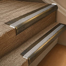 Solid brass 63.5mm bullnose stair nosing fitted to a step - Antique Brass with Cloud Castellated insert