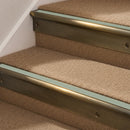 Antique Brass finish with Jade Castellated insert - 63.5mm solid brass bullnose stair nosing fitted to a carpeted step
