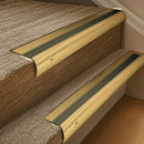 Solid brass 63.5mm bullnose stair nosing fitted to a step - Polished Brass with Antique Bronze insert