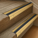 Solid brass 63.5mm bullnose stair nosing fitted to a step - Polished Brass with Black Olympic Grip insert