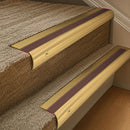 Solid brass 63.5mm bullnose stair nosing fitted to a step - Polished Brass with Claret Castellated insert