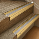 Solid brass 63.5mm bullnose stair nosing fitted to a step - Polished Brass with Cloud Castellated insert