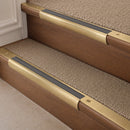 Satin Brass finish with Flint Castellated insert - 63.5mm solid brass bullnose stair nosing fitted to a carpeted step