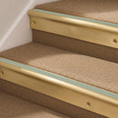 Satin Brass finish with Jade Castellated insert - 63.5mm solid brass bullnose stair nosing fitted to a carpeted step