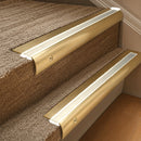 Solid brass 63.5mm bullnose stair nosing fitted to a step - Satin Brass with Porth Stone Smooth Textured insert