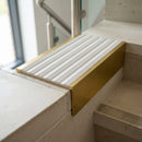 Solid brass 59mm slimline stair nosing with Cloud Castellated anti-slip insert fitted to a concrete step in a commercial stairwell