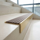 Solid brass 59mm slimline stair nosing with Fawn Castellated anti-slip insert fitted to a concrete step in a commercial stairwell