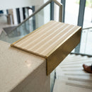 Solid brass 59mm slimline stair nosing with Ivory Castellated anti-slip insert fitted to a concrete step in a commercial stairwell