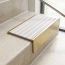 Solid brass 59mm slimline stair nosing with Light Grey Castellated anti-slip insert fitted to a concrete step in a commercial stairwell
