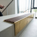 Solid brass 59mm slimline stair nosing with Peat Castellated anti-slip insert fitted to a concrete step in a commercial stairwell
