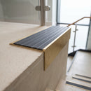 Solid brass 59mm slimline stair nosing with Regency Castellated anti-slip insert fitted to a concrete step in a commercial stairwell