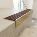 Solid brass 59mm slimline stair nosing with Rustic Castellated anti-slip insert fitted to a concrete step in a commercial stairwell