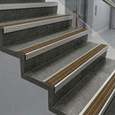 Square front aluminium stair nosings with bronze aluminium inserts on dark concrete steps
