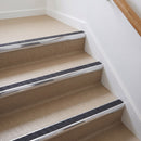 Bullnose aluminium stair nosing with a dark charcoal Mor Grip insert in bright polished finish fitted on a flat or apartment communal stair finished in beige vinyl