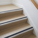 Bullnose aluminium stair nosing with a dark charcoal Mor Grip insert in mill finish finish fitted on a flat or apartment communal stair finished in beige vinyl