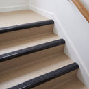 Bullnose aluminium stair nosing with a dark charcoal Mor Grip insert in satin black finish fitted on a flat or apartment communal stair finished in beige vinyl