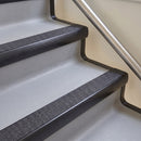 Bullnose aluminium stair nosing with a dark charcoal Mor Grip insert in satin black finish fitted on a hotel or office stair finished in light grey vinyl