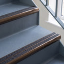 Bullnose aluminium stair nosing with twin dark charcoal Mor Grip inserts in dark bronze finish fitted on a hospital or clinic stair finished in blue-grey safety vinyl