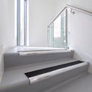 Bullnose DDA aluminium stair nosing 70 x 56mm in Bright Polished with Obsidian High Grip insert, fitted to grey vinyl stairs in an office stairwell