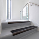 Bullnose DDA aluminium stair nosing 70 x 56mm in Dark Bronze with Obsidian High Grip insert, fitted to grey vinyl stairs in an office stairwell