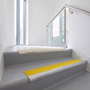 Bullnose DDA aluminium stair nosing 70 x 56mm in Mill Finish with Brimstone Exterior Grip insert, fitted to grey vinyl stairs in an office stairwell