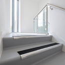 Bullnose DDA aluminium stair nosing 70 x 56mm in Mill Finish with Obsidian High Grip insert, fitted to grey vinyl stairs in an office stairwell