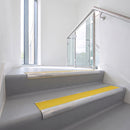 Bullnose DDA aluminium stair nosing 70 x 56mm in Mill Finish with Solar High Grip insert, fitted to grey vinyl stairs in an office stairwell