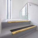 Bullnose DDA aluminium stair nosing 70 x 56mm in Mirrorflect Gold with Coal Exterior Grip insert, fitted to grey vinyl stairs in an office stairwell