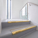 Bullnose DDA aluminium stair nosing 70 x 56mm in Mirrorflect Gold with Everest Exterior Grip insert, fitted to grey vinyl stairs in an office stairwell