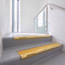 Bullnose DDA aluminium stair nosing 70 x 56mm in Mirrorflect Gold with Solar High Grip insert, fitted to grey vinyl stairs in an office stairwell
