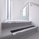 Bullnose DDA aluminium stair nosing 70 x 56mm in Mirrorflect Silver with Coal Exterior Grip insert, fitted to grey vinyl stairs in an office stairwell