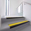 Bullnose DDA aluminium stair nosing 70 x 56mm in Satin Black with Brimstone Exterior Grip insert, fitted to grey vinyl stairs in an office stairwell