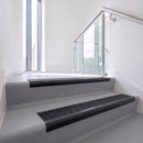 Bullnose DDA aluminium stair nosing 70 x 56mm in Satin Black with Coal Exterior Grip insert, fitted to grey vinyl stairs in an office stairwell