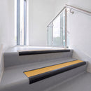Bullnose DDA aluminium stair nosing 70 x 56mm in Satin Black with Solar High Grip insert, fitted to grey vinyl stairs in an office stairwell