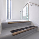 Bullnose DDA aluminium stair nosing 70 x 56mm in Satin Bronze with Coal Exterior Grip insert, fitted to grey vinyl stairs in an office stairwell