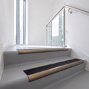 Bullnose DDA aluminium stair nosing 70 x 56mm in Satin Bronze with Obsidian High Grip insert, fitted to grey vinyl stairs in an office stairwell