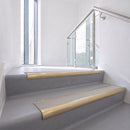 Bullnose DDA aluminium stair nosing 70 x 56mm in Satin Gold with Everest Exterior Grip insert, fitted to grey vinyl stairs in an office stairwell
