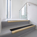 Bullnose DDA aluminium stair nosing 70 x 56mm in Satin Gold with Obsidian High Grip insert, fitted to grey vinyl stairs in an office stairwell