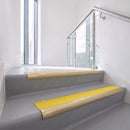 Bullnose DDA aluminium stair nosing 70 x 56mm in Satin Gold with Solar High Grip insert, fitted to grey vinyl stairs in an office stairwell