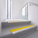 Bullnose DDA aluminium stair nosing 70 x 56mm in Satin Silver with Brimstone Exterior Grip insert, fitted to grey vinyl stairs in an office stairwell