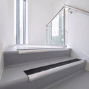 Bullnose DDA aluminium stair nosing 70 x 56mm in Satin Silver with Coal Exterior Grip insert, fitted to grey vinyl stairs in an office stairwell