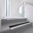 Bullnose DDA aluminium stair nosing 70 x 56mm in Satin Silver with Obsidian High Grip insert, fitted to grey vinyl stairs in an office stairwell