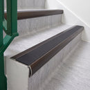 Dark Bronze 70 x 37mm bullnose stair nosing, Obsidian High Grip insert, on vinyl school stairs