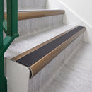 Satin Bronze 70 x 37mm bullnose stair nosing, Obsidian High Grip insert, on vinyl school stairs