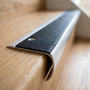 Close-up of the bullnose stair nosing showing the textured PVC anti-slip insert, countersunk fixing hole and curved 39mm nose